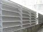 ACU-LAM Louvered Deflector installed on a weir, efficiently preventing floating debris in CSO systems with its stainless steel construction and low hydraulic resistance.