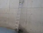 TRU-CLIMB Floating Ladder installed on a structure, designed for easy access with stainless steel construction and perforated bars for a secure grip.